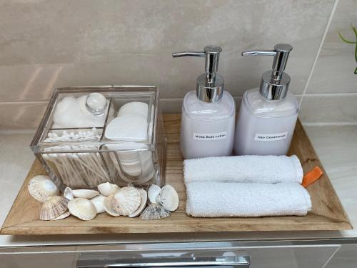 金瓦拉Atlantic Retreat Lodge的浴室内备有毛巾和2个肥皂机的托盘