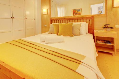 阿德耶Orlando - Sea View Apartment in Costa Adeje的卧室配有一张带黄色枕头的大型白色床。