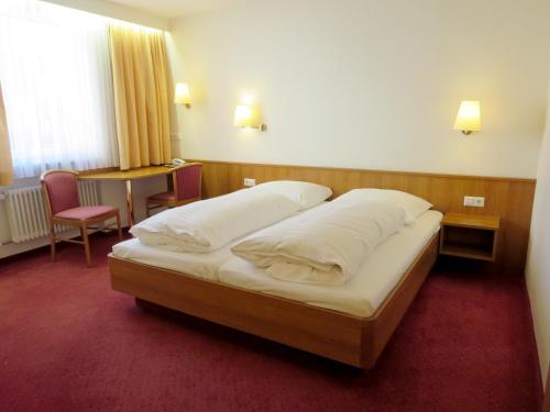 斯图加特范德尔酒店的一间卧室配有一张大床和两个枕头