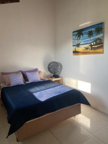 泰巴Pousada Vila do Mar的一间卧室配有一张带蓝色棉被的床