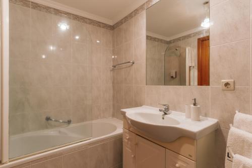 丰沙尔Residência Costa do Sol的浴室配有盥洗盆、浴缸和盥洗盆