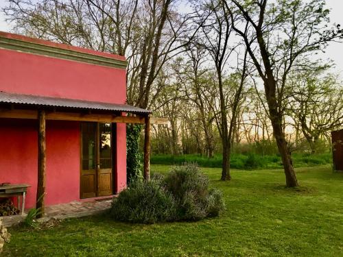 拉斯弗洛雷斯Casa de Campo La Colorada的院子里有长凳的红色房子