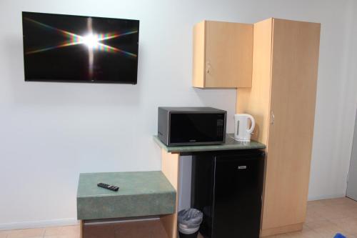 Thursday IslandTI Motel Torres Strait的一间配有微波炉的房间和墙上的电脑