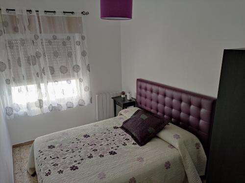 La FregenedaCasa El Callejo de La Fregeneda的卧室内一张带紫色床头板的床