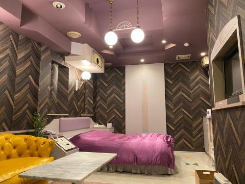 Settsu沙邦酒店（仅限成人入住）的一间卧室配有一张紫色的床和一张桌子