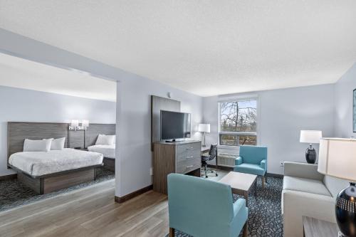 卡尔加里Emerald Hotel & Suites Calgary Airport的一间酒店客房,配有一张床和一台电视