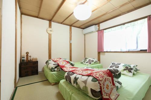 Kizuna Guesthouse的客房设有两张床和窗户。