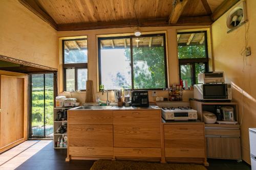 Kizuna Guesthouse的厨房配有带水槽和窗户的柜台。
