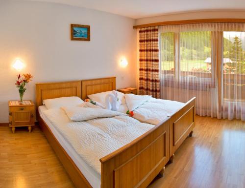 萨斯格伦德阿德勒酒店的一间卧室配有一张带白色床单的床和一扇窗户。