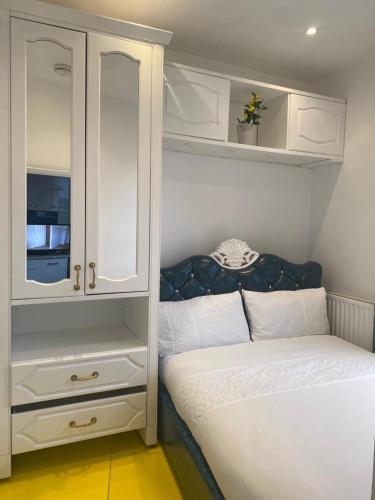 伦敦Ziggla Luxury Apartments的一间带床和橱柜的小卧室