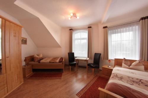 哥达帕松姆奥斯巴霍夫旅馆的一间卧室配有一张床、一张沙发和两个窗户。