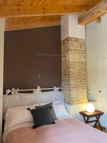 Vignale罗坎达伊尔中庭旅馆的一间卧室设有一张床和砖墙