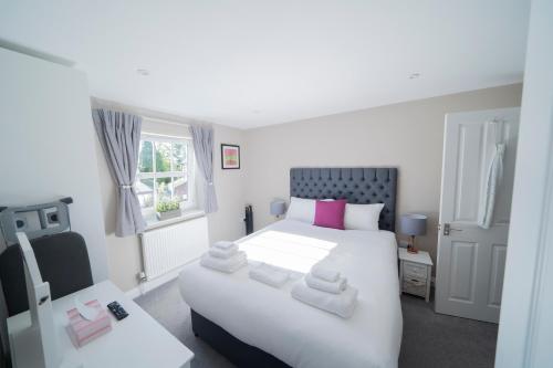 索尔兹伯里梨树服务式公寓的卧室设有一张白色大床和一扇窗户。