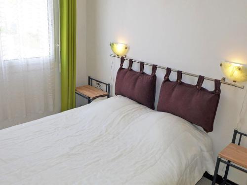 滨海圣皮埃尔圣皮埃尔海蓝拉美尔阿维德斯科尔赛尔斯酒店的一间卧室配有一张带两盏灯的大型白色床。
