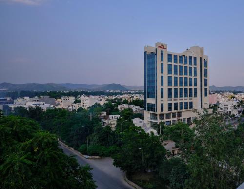 乌代浦Pride Hotel Udaipur的一座高大的建筑,有一条河在城市前