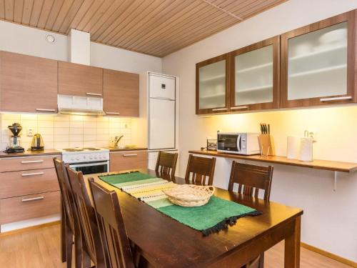 拉赫登佩拉Holiday Home Elvi by Interhome的一间带木桌和椅子的厨房和一间带柜台的厨房