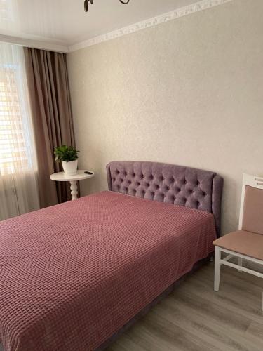 伊兹梅尔Квартира студия的一间卧室配有一张紫色的床和一把椅子