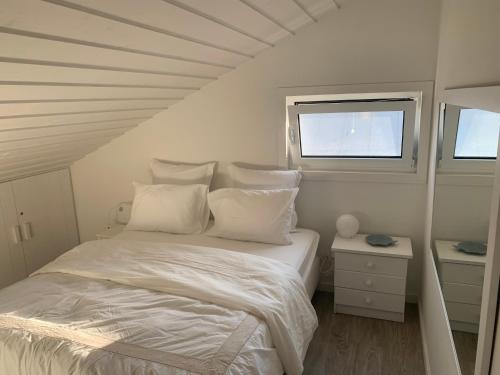 卡瓦利亚尔Lovely 2-bedroom apartment- Comporta的白色的卧室设有床和窗户