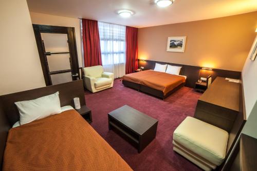 波德戈里察特米内斯酒店的酒店客房,配有两张床和椅子