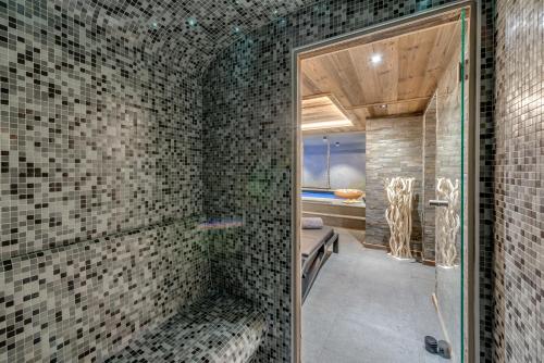 蒂涅Chalet Carte Blanche Merveilles的一间带淋浴的浴室,配有瓷砖墙壁