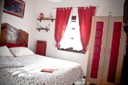 卡萨诺德莱穆尔杰B&b Parco Alta Murgia的一间卧室配有床和红色窗帘的窗户