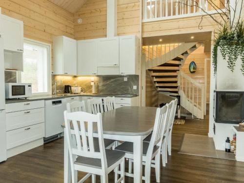 NarkausHoliday Home Aurora by Interhome的厨房配有白色橱柜和桌椅