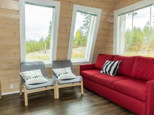 NarkausHoliday Home Aurora by Interhome的窗户的房间里设有一张红色的沙发和两把椅子