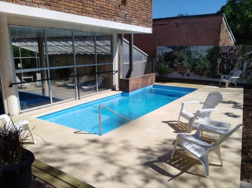 萨尔托Hotel Solar del Acuario的庭院设有带椅子的游泳池和房屋