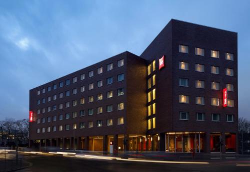 汉堡汉堡阿拉斯特瑞宜必思酒店的一座黑色的大建筑,上面有红色的标志