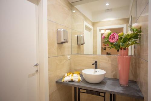 阿尔巴·阿德里亚蒂卡Hotel Flora的浴室设有水槽和花瓶