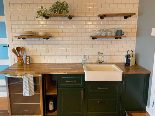 西基隆拿Les Chambres Roses的厨房配有绿色橱柜和水槽