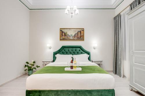 雅典Pandrosos Divine Suites的一间卧室配有一张绿色的床和吊灯。