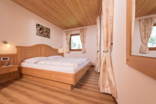 圣克里斯蒂娜Apartments La Rives的一间卧室配有一张床,铺有木地板