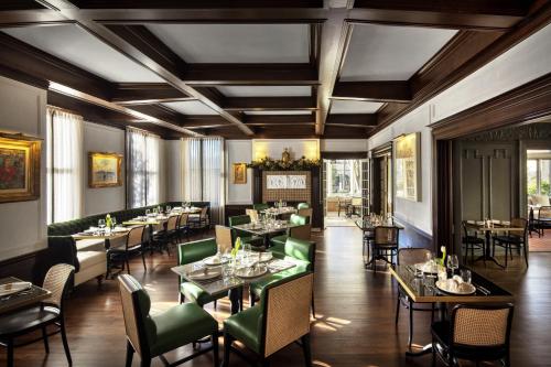 休斯顿La Colombe d'Or Hotel的用餐室配有桌子和绿色椅子