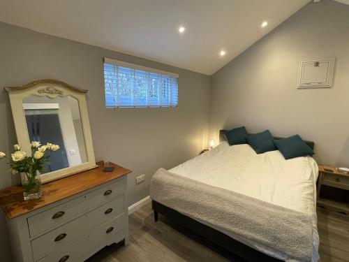 West BradfordBeautiful self-catering cottages, Ribble Valley的一间卧室配有一张带梳妆台和镜子的床