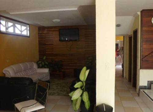 巴拉那州蓬塔尔Hotel Morada de Leste的客厅配有沙发和墙上的电视