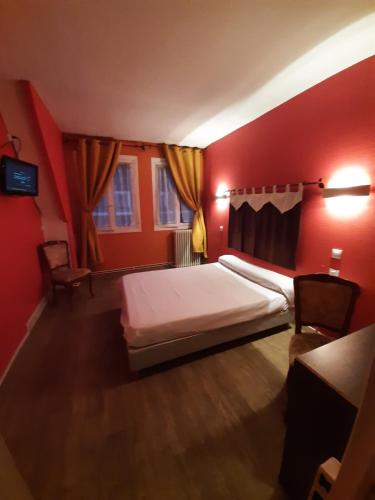 博韦季内酒店的红色卧室配有床和两把椅子