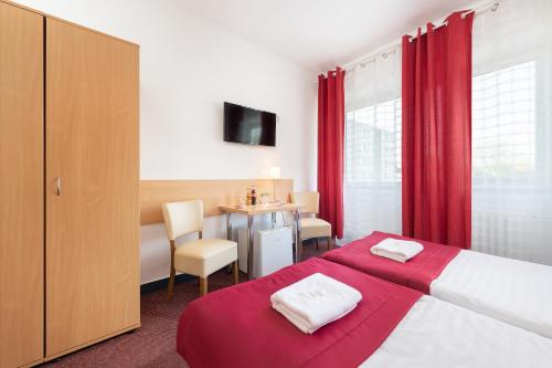 布拉迪斯拉发普乐斯酒店的酒店客房,配有一张床和一张桌子及椅子