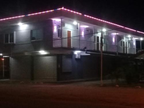 ZanderijDouglas Airport Guesthouse的带阳台的房屋,晚上有灯