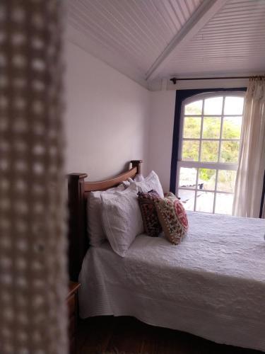 欧鲁普雷图É Hostel的卧室配有带枕头的床铺和窗户。
