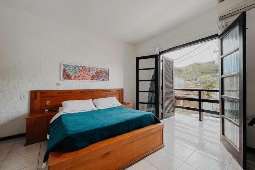 布希奥斯Búzios Centro Hotel的一间卧室设有一张床和一个大窗户