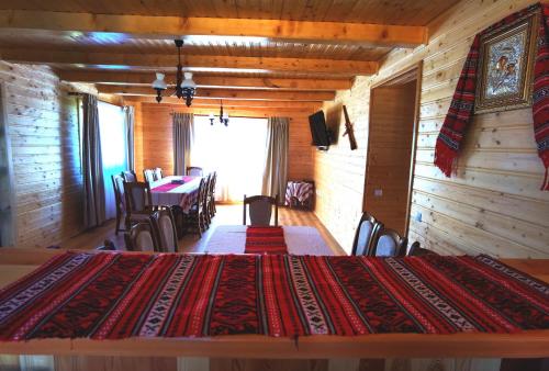 马里瑟尔Cabanele FloriCrin - Cabana Mare的小屋内带大床的用餐室