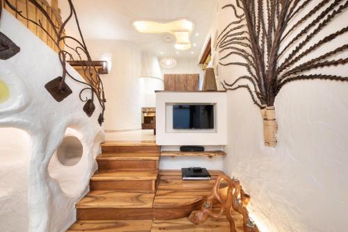克拉科夫克拉克之屋酒店的客厅设有楼梯、电视和符合人体工程学的植物