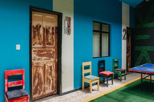 伊皮亚莱斯XanticoHostal的一间设有五颜六色椅子和门的房间