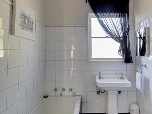 仙女港Mary Grant的白色的浴室设有浴缸和水槽。
