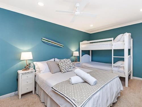 仙女港Iluka的一间卧室设有两张双层床,拥有蓝色的墙壁。