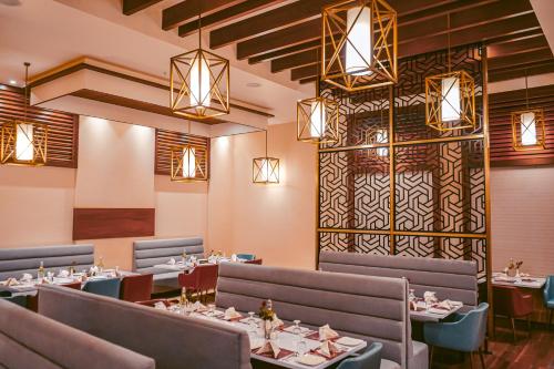 JagdalpurHOTEL AVINASH INTERNATIONAL的用餐室配有桌椅和灯光