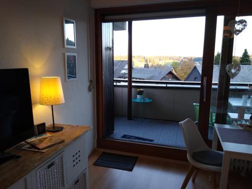 申瓦尔德Apartment 365 mit Sauna, Schwimmbad und Fitness的客厅设有大窗户和一张带台灯的桌子