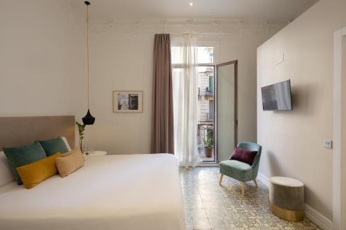 巴塞罗那Forget Me Not Barcelona的卧室配有一张白色大床和一把椅子