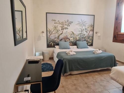 马德里加尔德拉韦拉Hosteria Casa Colonial的一间卧室配有两张床、一张书桌和一幅画